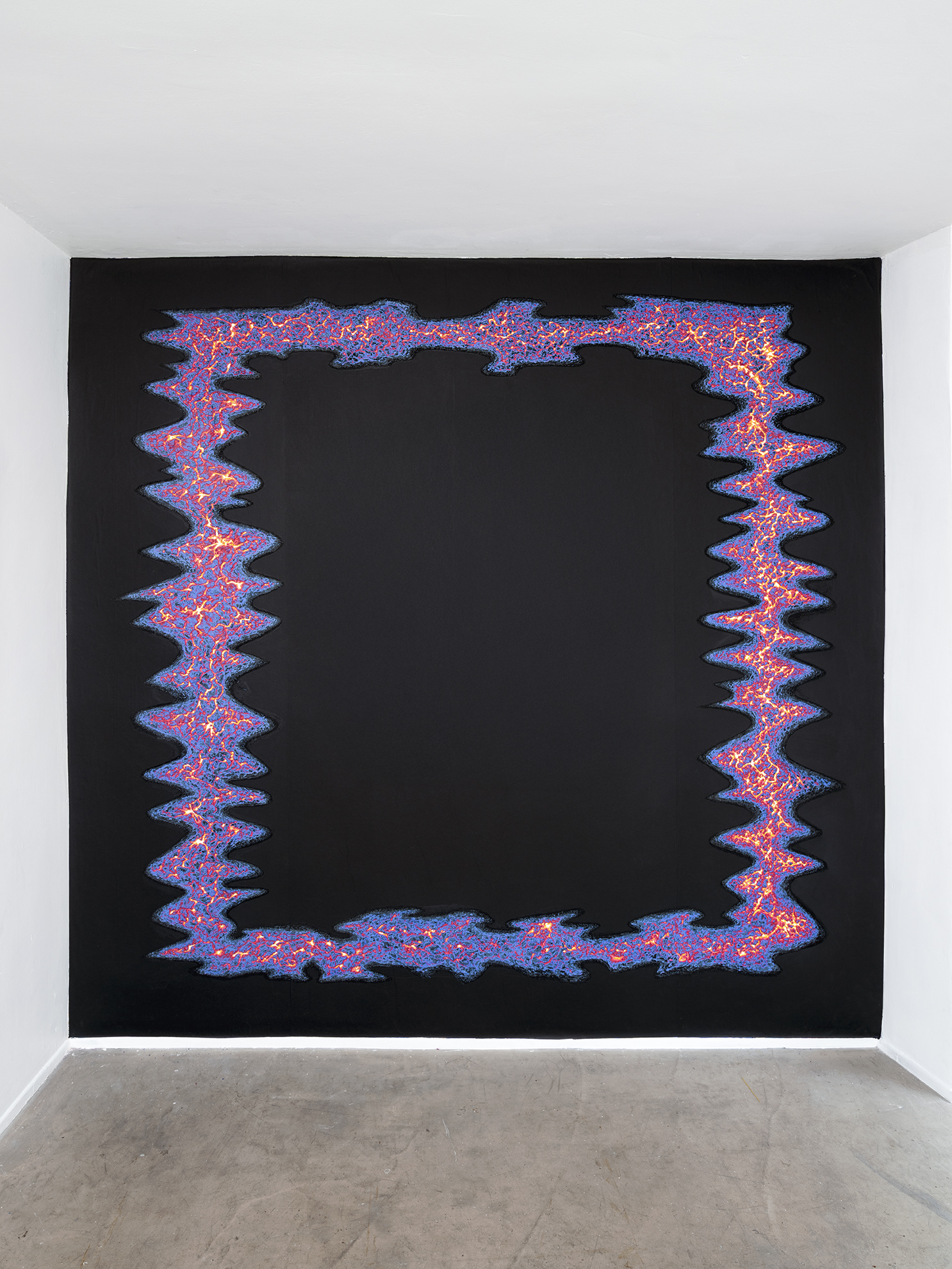 Vue d'ensemble de l'oeuvre de 2025 intitulée Le Portail, de la série Dégradé, mesurant 278 cm par 272 cm et réalisée in situ à la galerie les 2 portes à Besançon, France, en Juillet 2025. Dans cette série de dessins commencée en 2021, l’artiste Patrick Martinez-Mees a mis au point un procédé plastique où un certain nombre des feuilles de papier de différentes couleurs sont superposées dans un ordre déterminé ou non et collées les unes sur les autres pour former un " sandwich" ou un " mille-feuilles" de papier. Le dessin est ensuite obtenu en creusant la surface de papier à l'aide d'un outil rotatif muni d'une fraise abrasive permettant de mettre à jour les différentes strates de couleur enfouies à différentes profondeur. L’oeuvre immersive “ le Portail” d’assez grande dimensions, couvre la totalité de l’un des murs d’exposition de la galerie. Sur un fond noir, une forme ondoyante ressemblant a un cadre multicolore plus ou moins épais semble suivre en ondulant le pourtour du mur. Meme si elle s’en rapproche, la forme ne touche jamais les limites externes du mur. Le centre de l’oeuvre, vide lui aussi, est noir. Les couleurs de ce cadre vague, allant du noir au blanc en passant par le bleu foncé, le violet, le rouge, le rose, et le jaune orangé ainsi que les motifs de craquelures et de failles à l’intérieur, évoquent de la lave en fusion cherchant son chemin sous la croute murale. Le spectateur est invité à s’éloigner pour découvrir le motif de l’onde dans son ensemble ou au contraire de s’approcher pour plonger dans les details du relief et les infractuosités du papier minutieusement dechiqueté.